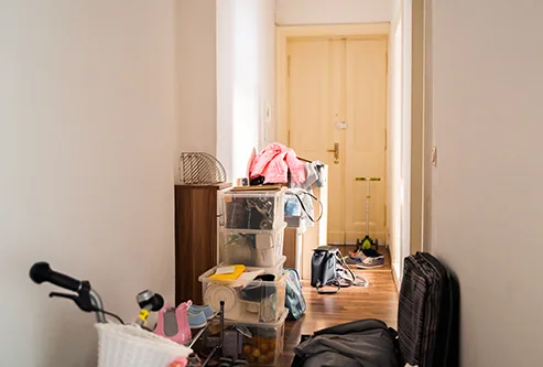 Avant : couloir encombré de cartons et de sacs, puis vidé et propre